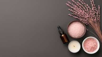 Flat lay of various spa-related items arranged on a dark grey background.