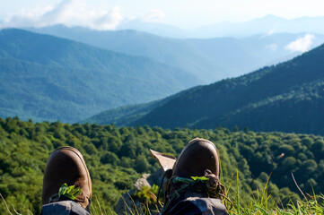Hiking torn boots is hang on background mountains