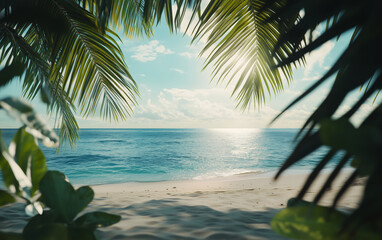 View of the sandy beach and blue ocean through the green leaves of palm trees and tropical plants