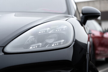 Fototapeta premium black car headlight, close up view, car dealing and manufacturing, cropped car image