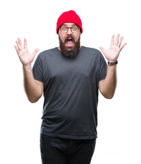 Naklejka premium Young caucasian hipster man wearing glasses over isolated background celebrating crazy and amazed for success with arms raised and open eyes screaming excited. Winner concept