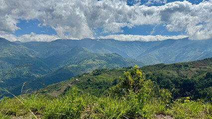 Montañas con cielo azul, nubes y vegetación