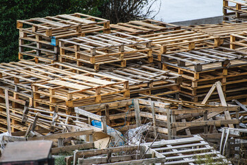 Stacks of Wooden Pallets in Outdoor Storage Area Highlighting Reusability and Industrial Waste