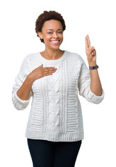Beautiful young african american woman wearing sweater over isolated background Swearing with hand...