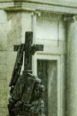 Sculpture of a cross with a closed book resting on it. Rainy day. São João Batista Cemetery, Rio de Janeiro. In Christian culture, the cross symbolizes overcoming death and the closed book shows that 