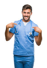 Young handsome doctor surgeon man over isolated background looking confident with smile on face, pointing oneself with fingers proud and happy.