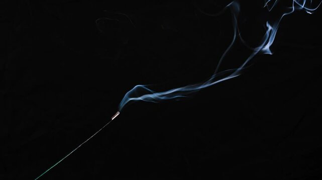 dance of incense smoke with light in the dark