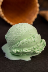 green ice cream with mint flavor on a black slate surface