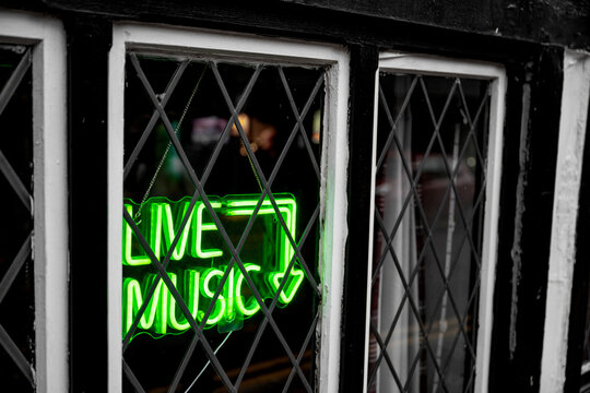 Live music green neon sign in a pub window with arrow