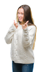 Young beautiful caucasian woman wearing winter sweater over isolated background pointing fingers to camera with happy and funny face. Good energy and vibes.