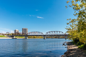 A bridge spans a river with a city in the background