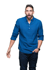 Fototapeta premium Young handsome man over isolated background In shock face, looking skeptical and sarcastic, surprised with open mouth