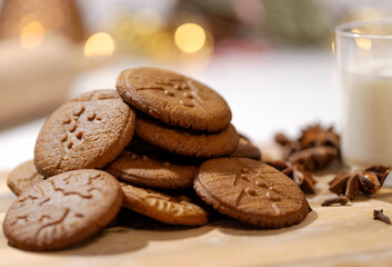 homemade gingerbread cookies with a glass of milk and spices: anise, cloves and cinnamon. traditional christmas dessert, christmas and new year celebration
