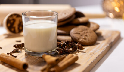 homemade gingerbread cookies with a glass of milk and spices: anise, cloves and cinnamon. traditional christmas dessert, christmas and new year celebration