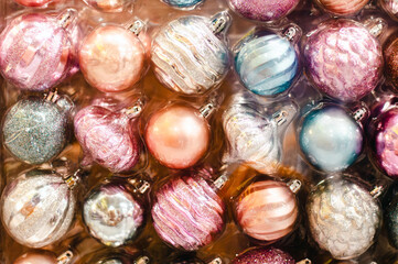 Close-up of Christmas and New Year's balls of various colors in a package, textured background