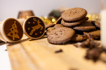 a wooden cookie cutter with a reindeer on it , hot gingerbread cookies and spices 