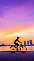 Obraz premium Cyclist rides along a waterfront path at sunset, silhouetted against a vibrant sky, AI