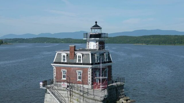 Historic New York lighthouse with mountains in the background, drone 4K