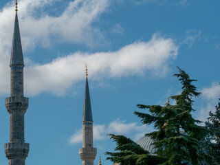 Obraz premium Detalle de alminar con árbol y nubes