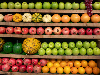 Fruta expuesta con melón, naranjas, granadas, calabazas y manzanas