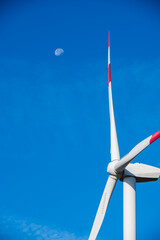 Close-up of a windmill propeller with the moon in the background