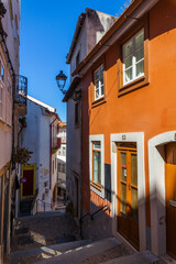 A narrow, cobblestone street winding its way through the historic heart of Coimbra, with charming traditional houses lining the way