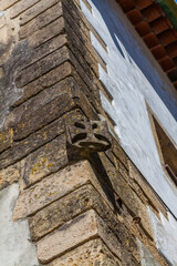 A weathered stone gargoyle, perched on the corner of a historic building