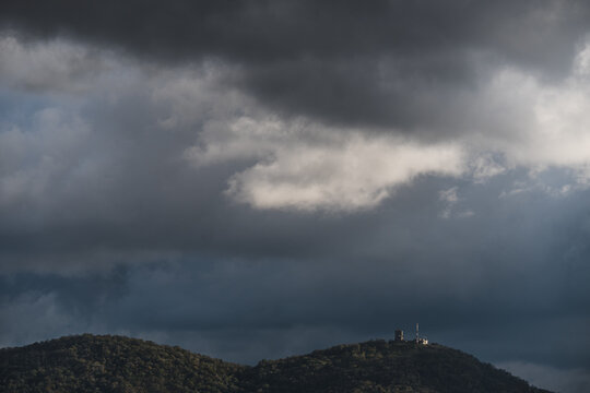 View of hills under rainy clouds