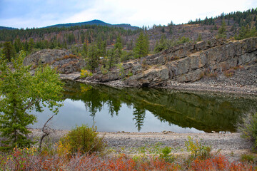 Photo of large Montana lake with reflections and cloudy sky background