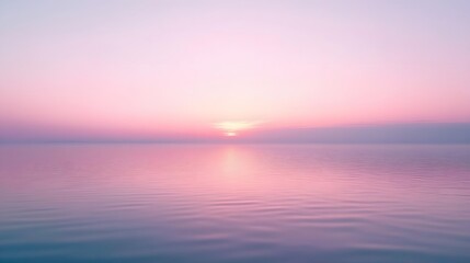Obraz premium Serene Pink Sunset Over Calm Ocean Water