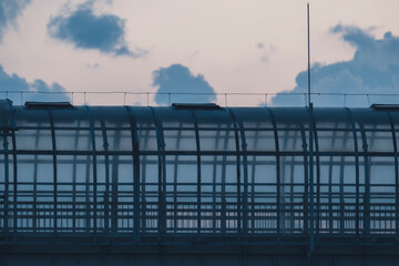 Obraz premium Urban pedestrian bridge with glass panels at sunset