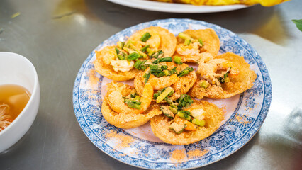 Banh khot, a Vietnamese cuisine. Popular in Vung Tau and the Mekong Delta. Savory mini pancakes made from a batter of rice flour, coconut milk, turmeric. They have golden hue color, subtle sweetness