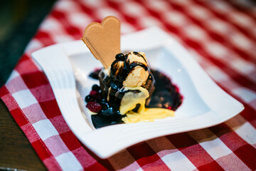 A classic dessert plate showcases creamy vanilla ice cream, warm berry compote, and a decorative cookie.