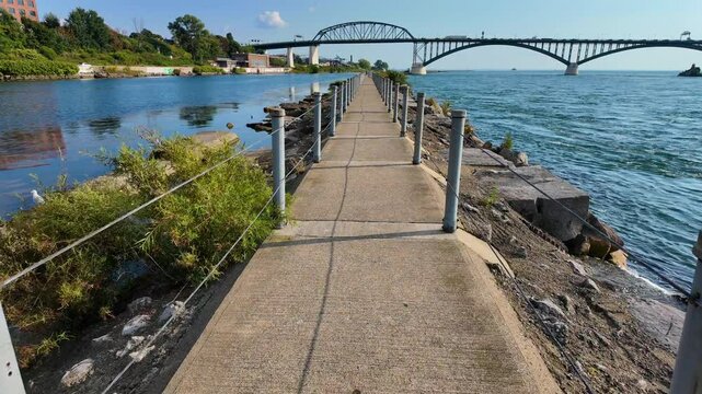 Immerse yourself in the scenic beauty of Buffalo, NY, with this POV Steadicam footage capturing a walk along the famed River Walk. This narrow concrete path winds gracefully with the Niagara River.