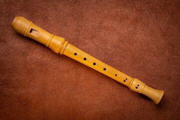 wooden recorder flute instrument, classic German style, against textured art paper © MarekPhotoDesign.com