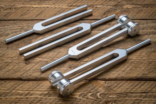 Set of weighted and unweighted metal tuning forks used for tuning musical instruments, sound therapy, chakra healing or relaxation.