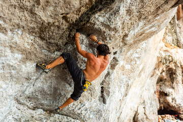 Extreme sport climbing on summer beach holiday vacation. Healthy young Asian man climber enjoy...
