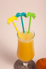 glass of mango juice with colorful mixers
