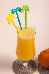 glass of mango juice with colorful mixers