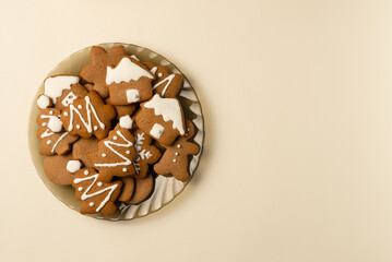 Plate with gingerbread on beige background. Christmas concept. Flat lay, top view. Copy space