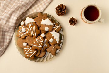Coziness composition with gingerbread and cup of tea on beige background. Christmas concept. Flat lay, top view.