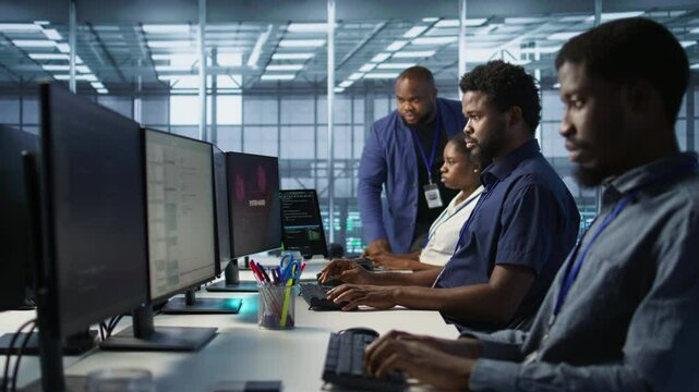 Server room engineers panicking after seeing disaster recovery plans fail, unable to avoid downtime. Stressed data center workers frightened after seeing performance drop while monitoring it, camera A