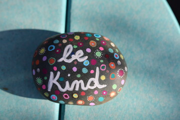Be kind kindness rock on blue table