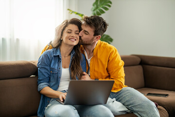 Happy Couple Relaxing Together With Laptop on Couch