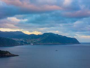 Aerial drone view of sunset over Azores islands. Ribeira Quente and Praia do Fogo. Landscape of Sao Miguel coastline with green mountains in Azores