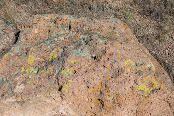 Carvings and Petroglyphs among the Colorful Lichen, carved by the Ancestral Puebloans on the Rock Walls of Bandelier National Monument, New Mexico, United States