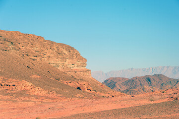 A desert landscape with a mountain in the background