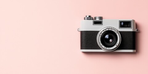 A vintage camera on a soft pink background, symbolizing photography and creativity.