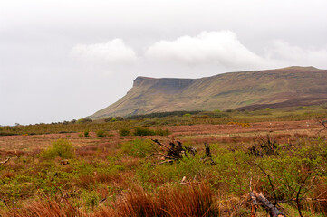 A large hill with a cloudy sky in the background