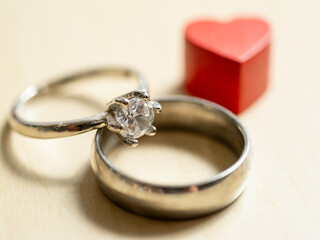 Symbols of commitment close-up of engagement ring and wedding band in romantic setting